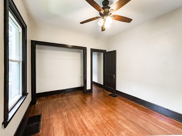 38 W 28th St, Covington, KY 41015 - unfurnished bedroom with visible vents, baseboards, wood finished floors, and multiple windows