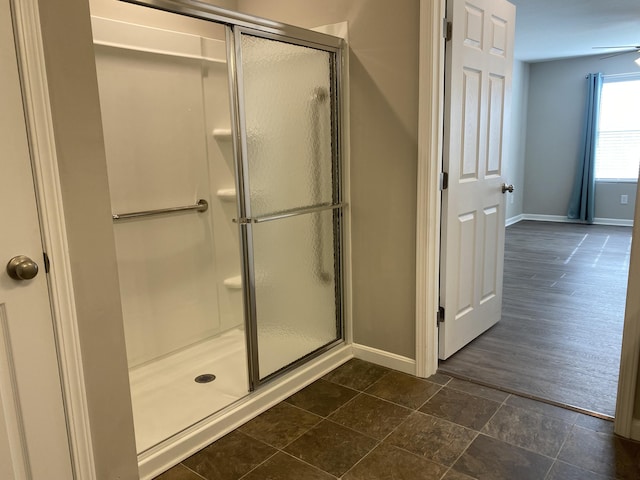 full bath with a shower stall and baseboards