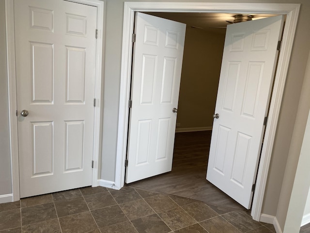 unfurnished bedroom featuring baseboards and stone finish floor