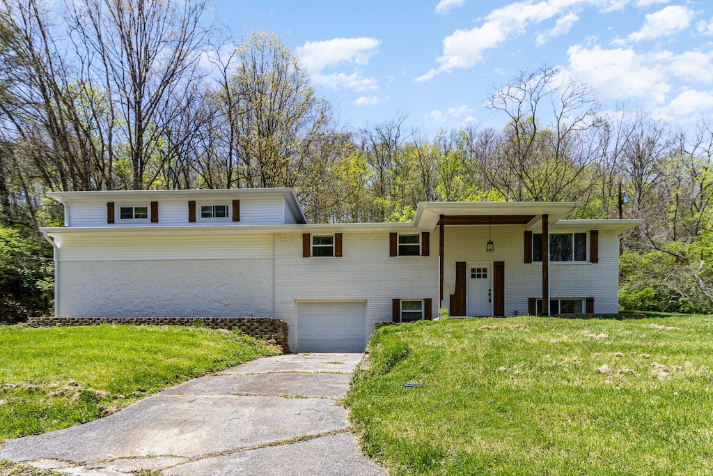 2433 Holdsbranch Rd, Fort Mitchell, KY 41017 - split foyer home with concrete driveway, brick siding, a front yard, and a garage