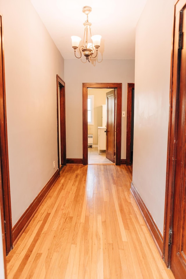 2225 Oakland Ave, Covington, KY 41015 - corridor with light wood finished floors, baseboards, a notable chandelier, and radiator