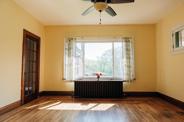 2225 Oakland Ave, Covington, KY 41015 - empty room featuring radiator, hardwood / wood-style floors, baseboards, and ceiling fan