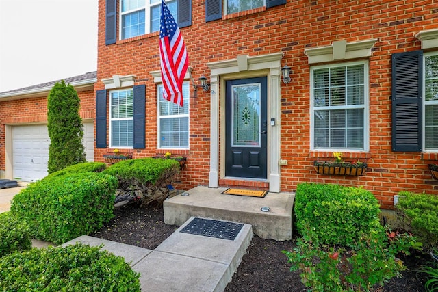 property entrance with a garage and brick siding