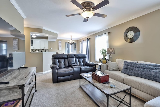 living area featuring light colored carpet, ornamental molding, and ceiling fan with notable chandelier