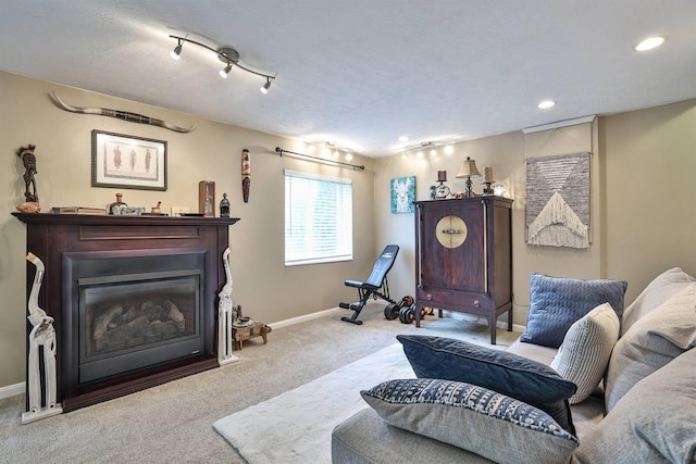 living room featuring a glass covered fireplace, carpet floors, baseboards, and recessed lighting