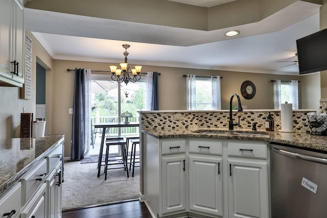 kitchen with stainless steel dishwasher, white cabinetry, ornamental molding, and a sink