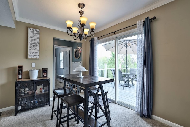 dining space featuring crown molding, baseboards, light carpet, and a chandelier