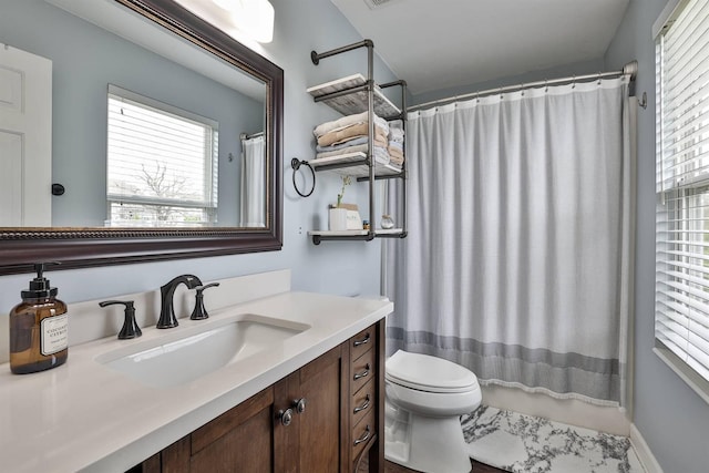 bathroom with a healthy amount of sunlight, vanity, toilet, and a shower with shower curtain
