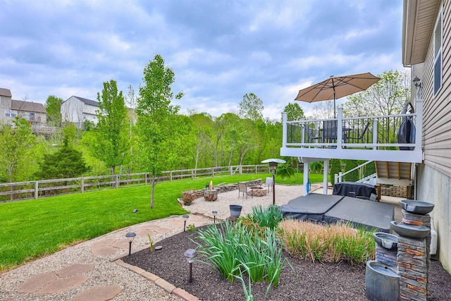 view of yard with a patio, a deck, a fenced backyard, and an outdoor fire pit