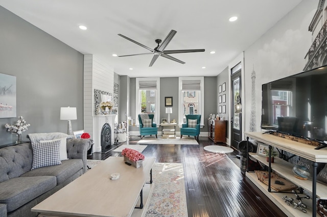 living area with a fireplace with flush hearth, a ceiling fan, dark wood-style floors, and recessed lighting