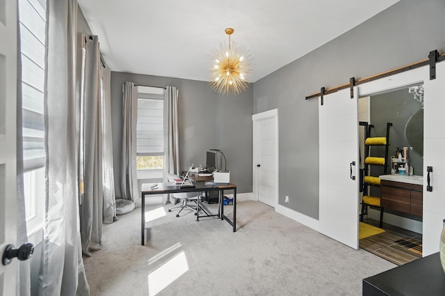 office area featuring baseboards, carpet, a notable chandelier, and a barn door