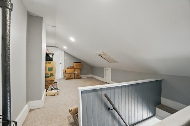 additional living space with baseboards, vaulted ceiling, and carpet