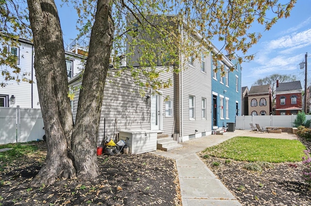 view of side of property featuring fence and entry steps