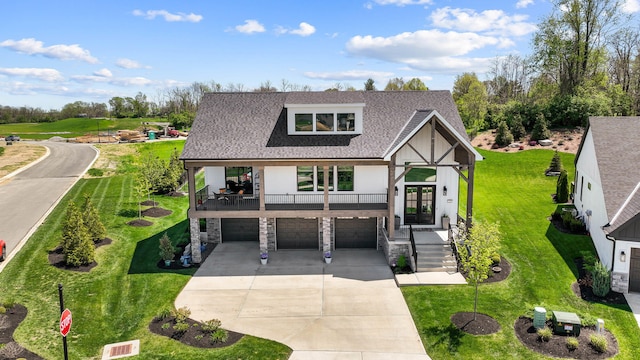 english style home with an attached garage, a front lawn, driveway, and stone siding