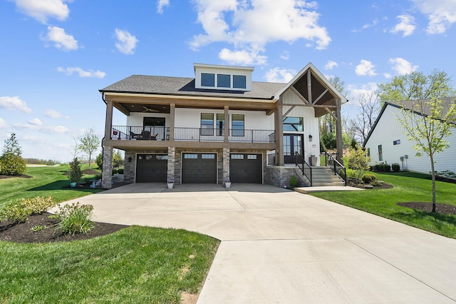 view of front of property with an attached garage, driveway, a balcony, and a front yard