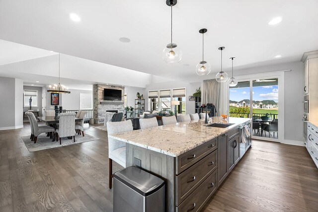 kitchen with dark wood finished floors, baseboards, a breakfast bar area, and a sink