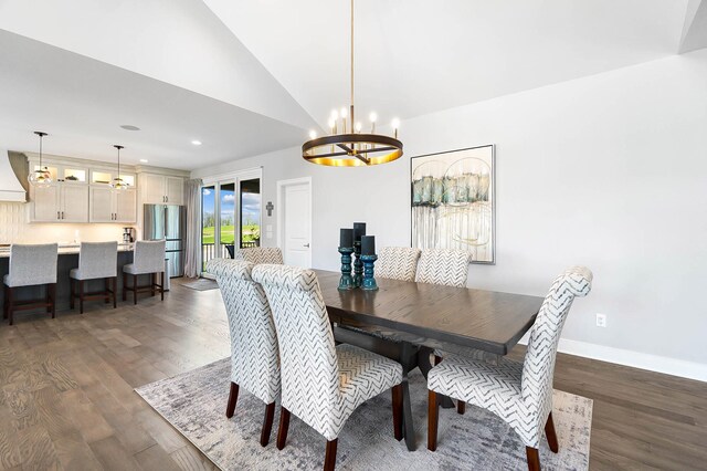 dining space with dark wood finished floors, vaulted ceiling, baseboards, recessed lighting, and a notable chandelier