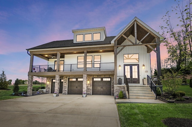 view of front of house with french doors, concrete driveway, a garage, a shingled roof, and a balcony