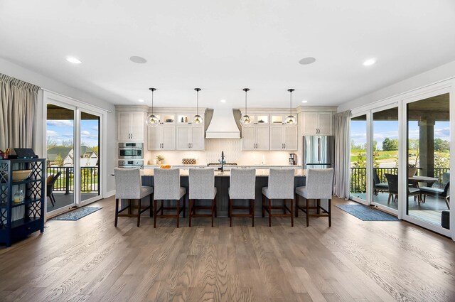 kitchen featuring a large island, recessed lighting, dark wood-style floors, and custom range hood
