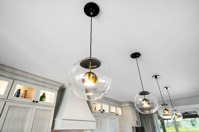 interior details with decorative light fixtures and glass insert cabinets