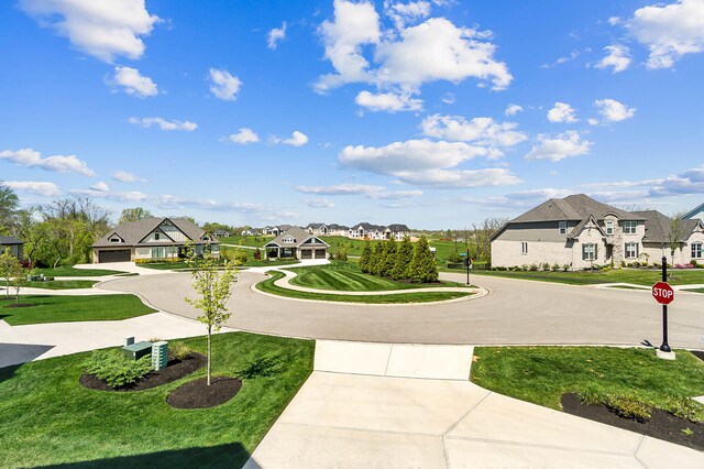 view of community with a lawn, curved driveway, and a residential view