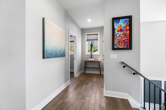 hallway featuring an upstairs landing, baseboards, dark wood-type flooring, and recessed lighting