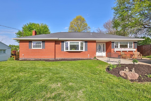 ranch-style home with brick siding, a chimney, a front yard, and fence