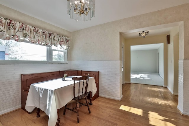 dining space with baseboards, a chandelier, and light wood-style floors