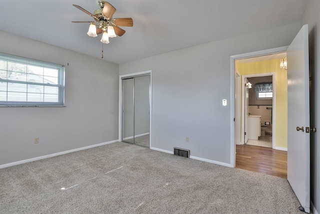 unfurnished bedroom with a ceiling fan, visible vents, baseboards, a closet, and carpet