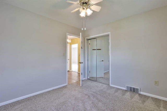 unfurnished bedroom featuring baseboards, carpet, a closet, and visible vents