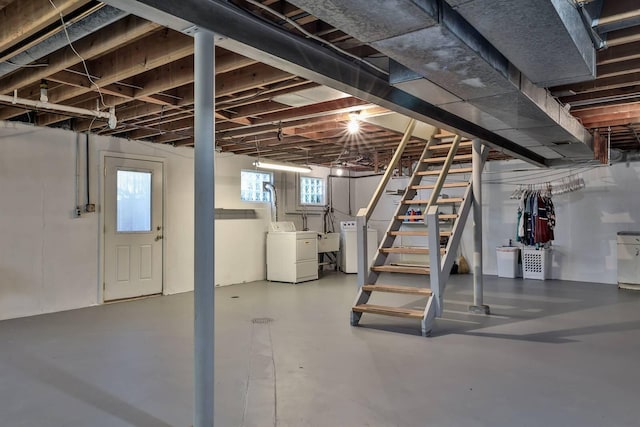 basement featuring a sink, stairway, and washing machine and clothes dryer