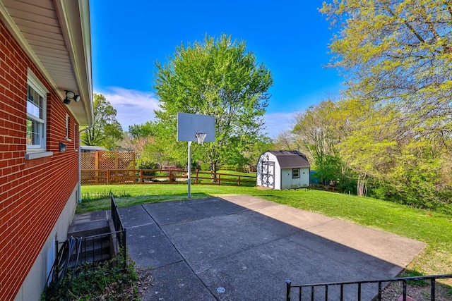 view of patio with a storage shed, fence, and an outbuilding