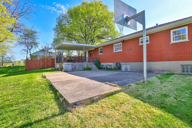 rear view of house featuring a lawn, fence, a patio area, and brick siding
