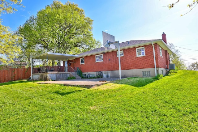 back of house featuring a lawn, fence, a chimney, and brick siding