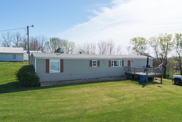 view of front of property featuring a deck, a front yard, and metal roof