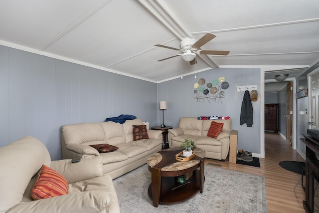 living room with wood finished floors, a ceiling fan, and lofted ceiling with beams