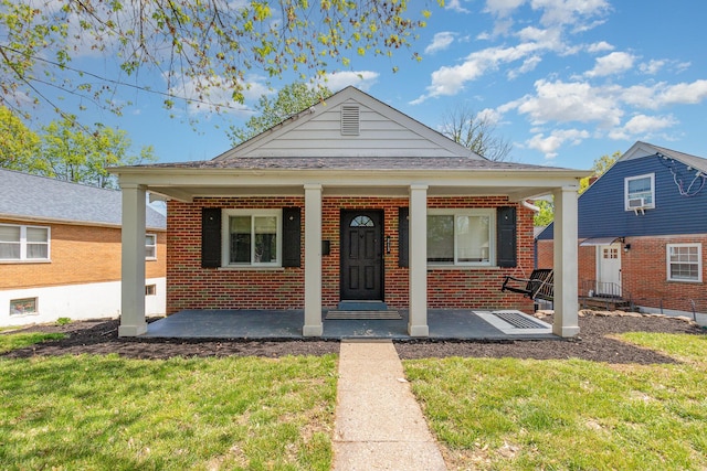 bungalow-style home featuring a front yard, a porch, and brick siding