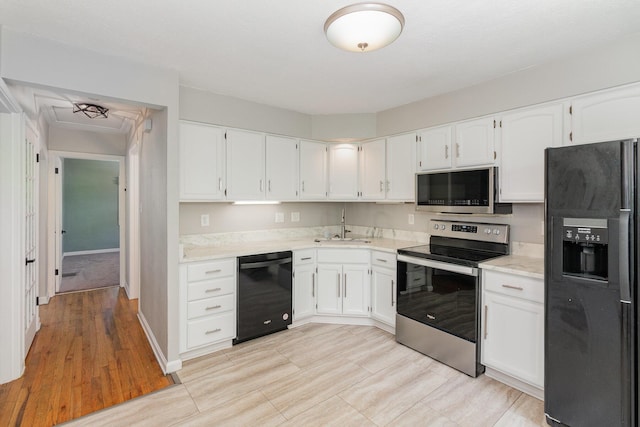 kitchen featuring a sink, white cabinets, and black appliances