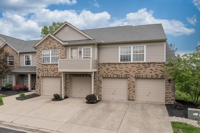 view of front facade with brick siding, driveway, a garage, and roof with shingles
