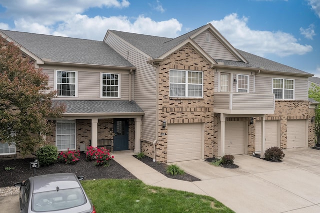 view of front facade with brick siding, driveway, an attached garage, a shingled roof, and covered porch