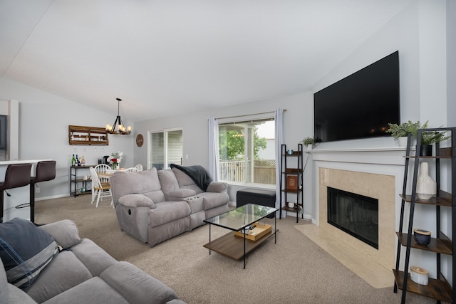 living area featuring carpet flooring, a chandelier, a fireplace, vaulted ceiling, and baseboards