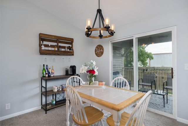 dining area featuring a chandelier, carpet floors, baseboards, lofted ceiling, and a textured ceiling