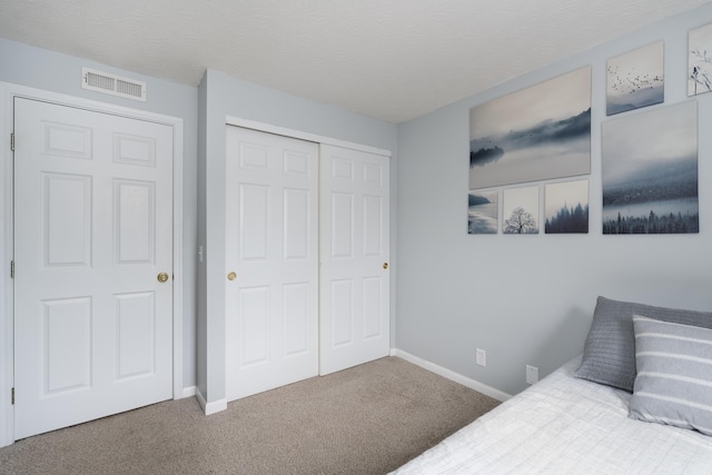 carpeted bedroom featuring a closet and baseboards