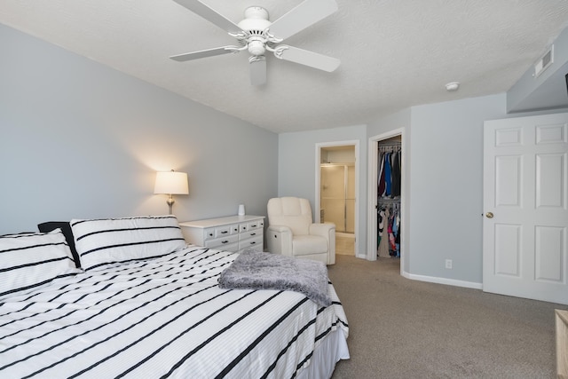 bedroom featuring light colored carpet, a walk in closet, a closet, baseboards, and ceiling fan