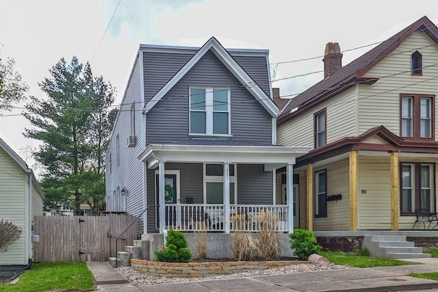 view of front of property featuring fence and a porch