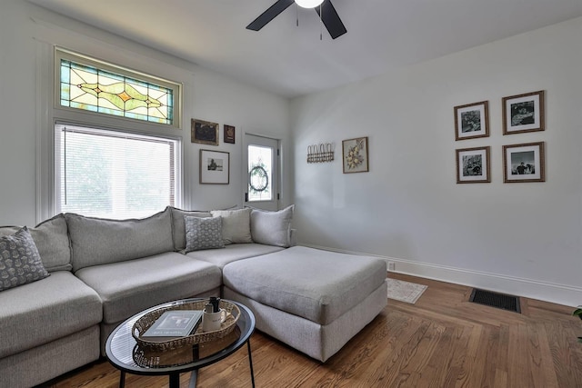 living room with visible vents, ceiling fan, and baseboards