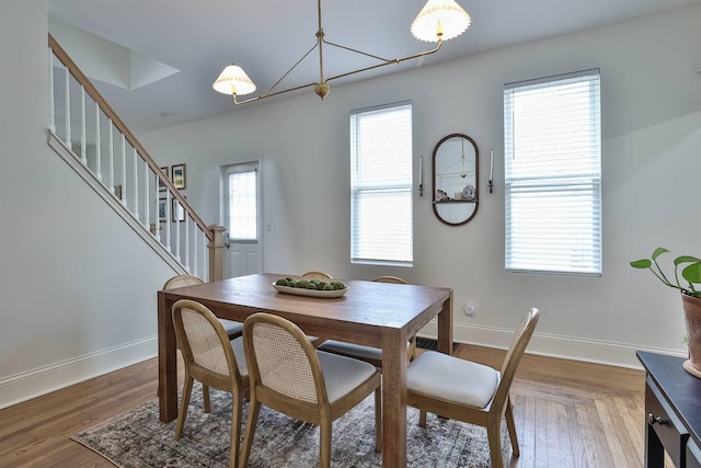 dining area with stairs, wood finished floors, and baseboards