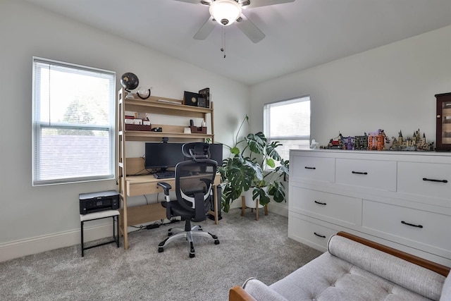 carpeted office space featuring baseboards and ceiling fan