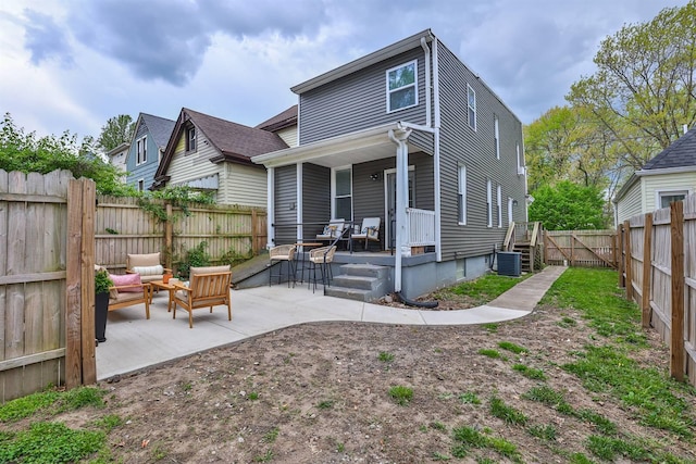 rear view of property with covered porch, a patio, a fenced backyard, and cooling unit