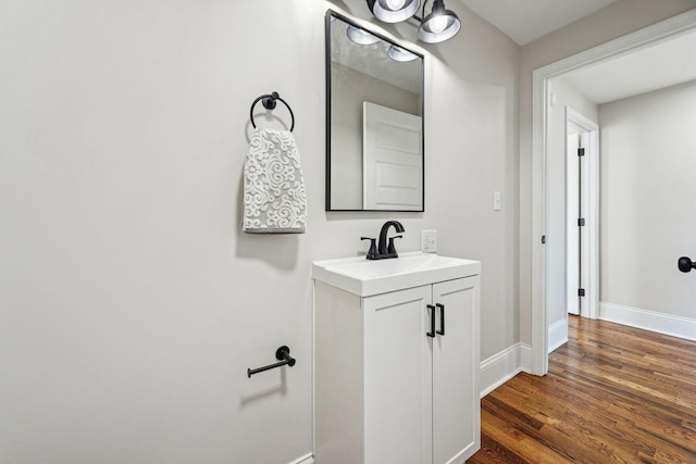 bathroom with vanity, baseboards, and wood finished floors
